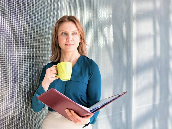 Mulher Negócios Sênior Segurando Caneca Amarela Escritório Enquanto Arquivos — Fotografia de Stock