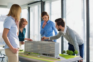 Ofislerinde bir model geliştirme etrafında çalışan bir grup mimar