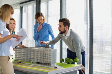 Ofislerinde bir model geliştirme etrafında çalışan bir grup mimar