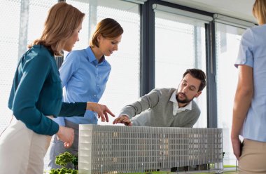 Ofislerinde bir model geliştirme etrafında çalışan bir grup mimar