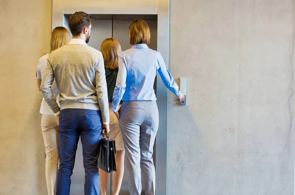 一群商人和妇女在办公室等电梯 — 图库照片