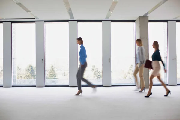 空のオフィスをゆっくりと歩いているビジネスの人々のグループ — ストック写真