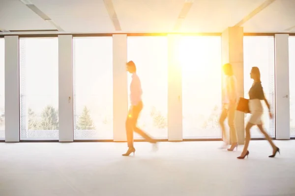 空のオフィスをゆっくりと歩いているビジネスの人々のグループ — ストック写真