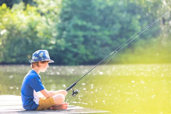 Young Boy Fishing Lake While Sitting Pier — Stok fotoğraf