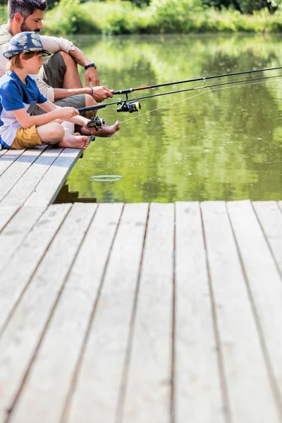 Padre Figlio Pesca Nel Lago Mentre Seduto Sul Molo — Foto Stock