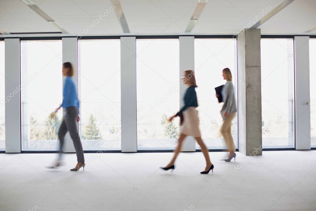 Group of business people slowly walking across empty office