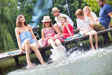 Annemin gölde çocuklarla su oynarken, göl kıyısındaki ailenin karşısında otururken çekilmiş bir fotoğrafı.