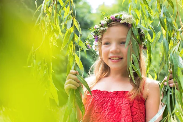 Portret Uśmiechniętej Dziewczyny Noszącej Kwiaty Stojącej Pośród Liści Parku — Zdjęcie stockowe