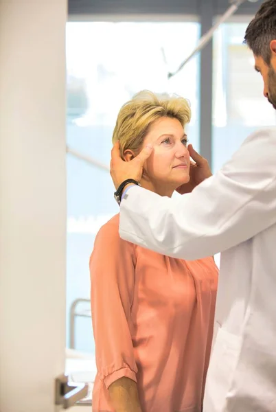 Doctor treating mature patient at hospital — Stock Photo, Image