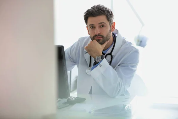 Retrato del médico confiado usando computadora en el escritorio en el hospital — Foto de Stock