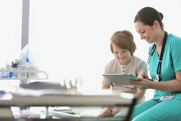 Enfermeira tocando tablet digital com paciente no hospital — Fotografia de Stock