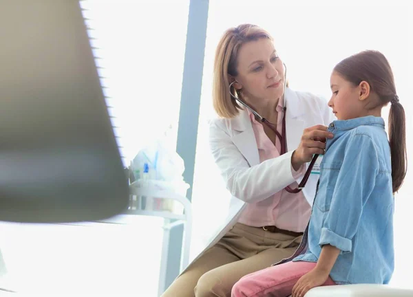 Självsäker läkare som kontrollerar hjärtslag hos barn — Stockfoto