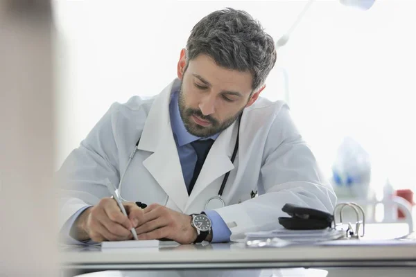 Arzt schreibt Rezept am Schreibtisch im Krankenhaus — Stockfoto