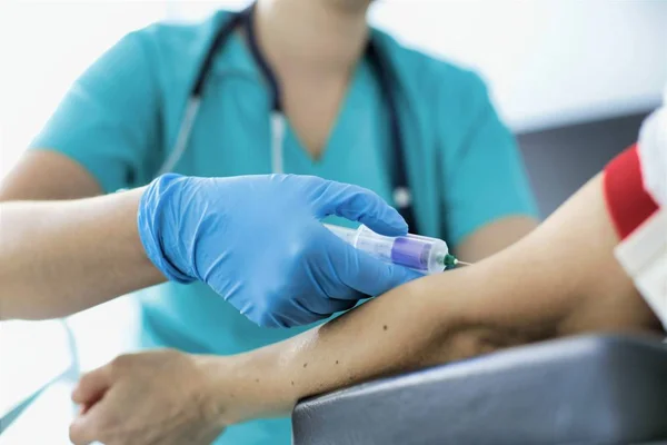 Nurse wearing gloves while injecting patient at hospital — Stock Photo, Image