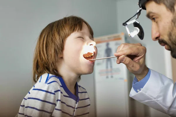 Doctor checking tonsils of patient at hospital — Stock Photo, Image