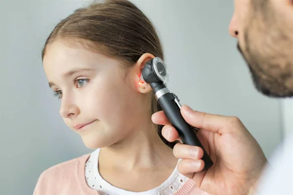 Doctor checking ear of patient at hospital — Stock Photo, Image