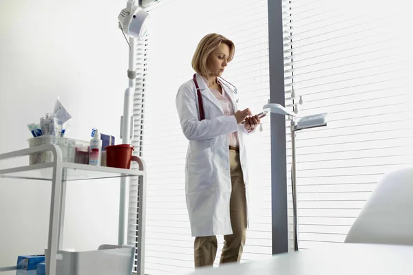 Confident pediatrician using smartphone at hospital — Stock Photo, Image