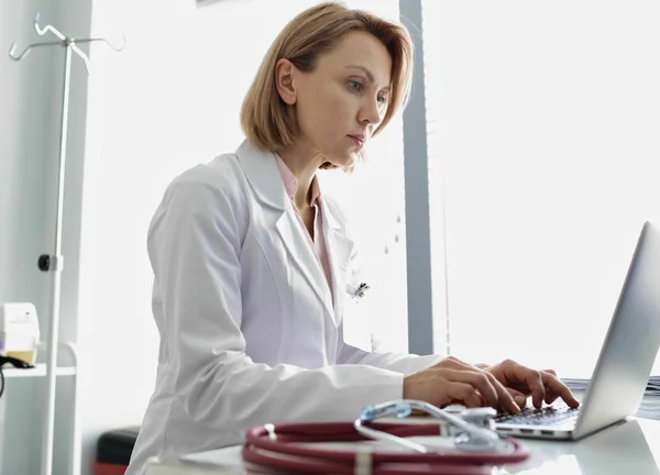 病院のコンピュータ机に座っている医師の肖像 — ストック写真
