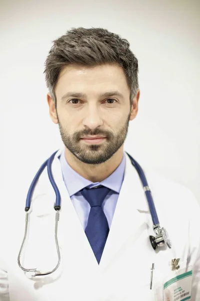 Portrait of handsome confident doctor in hospital — Stock Photo, Image