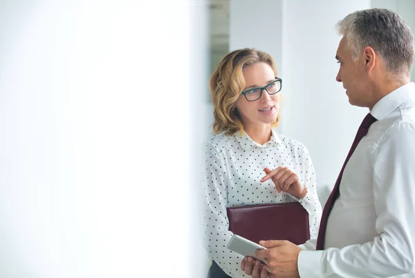 Smiling businesswoman looking at businessman standing in new off — Stock Photo, Image