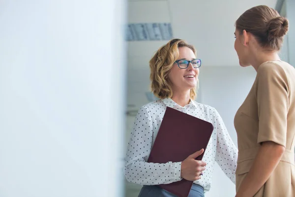 Confident businesswomen discussing while standing at new office — Stock Photo, Image