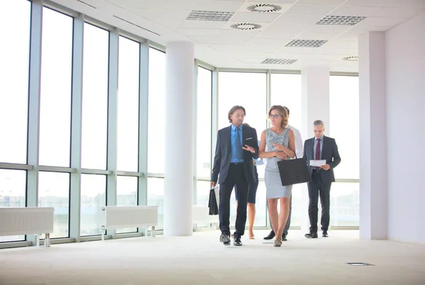 Volledige lengte van het bedrijfsleven collega 's lopen tijdens het praten in offi — Stockfoto