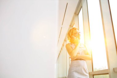 Ofiste akıllı telefon kullanan çekici bir kadın.