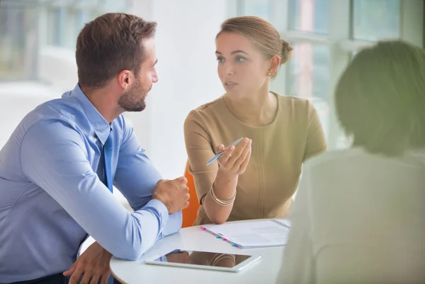 Young colleagues discussing over document at table during meetin — Stock Photo, Image