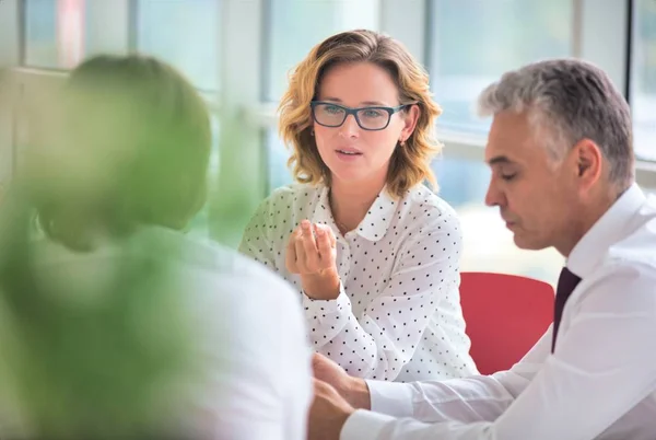 Unternehmenskollegen diskutieren am Tisch in neuem Outfit — Stockfoto