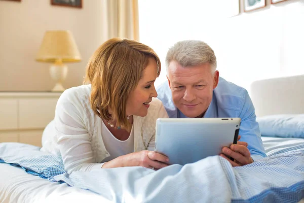 Lächelndes Älteres Paar Teilt Digitales Tablet Während Hause Bett Liegt — Stockfoto