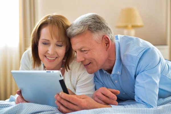 Glimlachen Volwassen Paar Delen Digitale Tablet Terwijl Liggend Bed Thuis — Stockfoto