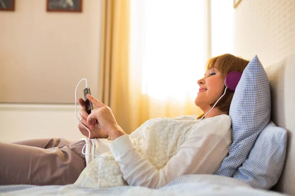 Volwassen vrouw luisteren naar muziek — Stockfoto