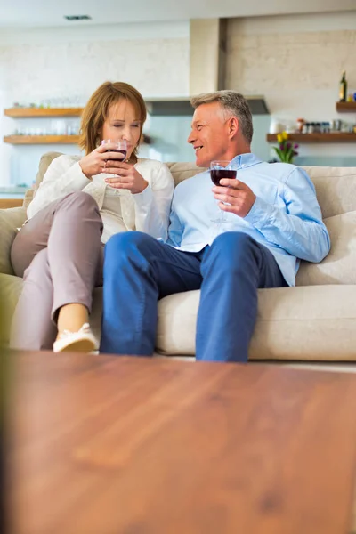 Smiling Mature Couple Sitting Sofa While Holding Drinks Home — Stock Photo, Image