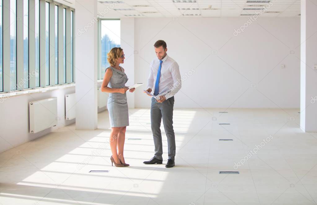 Businessman and businesswoman discussing over document at new of