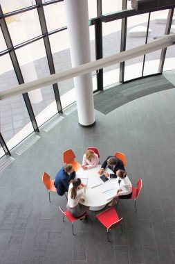 Toplantı sırasında ofiste otururken planlama iş meslektaşlarının yüksek açılı görünüş