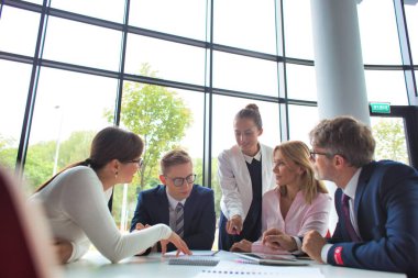 İş arkadaşları toplantı sırasında ofiste otururken plan yapıyorlar