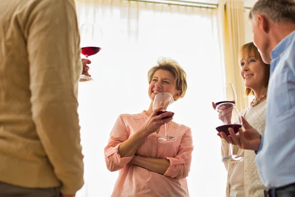 Souriant amis matures debout avec des boissons à la maison — Photo