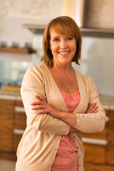 Portrait of smiling mature woman standing with arms crossed at h — Stock Photo, Image