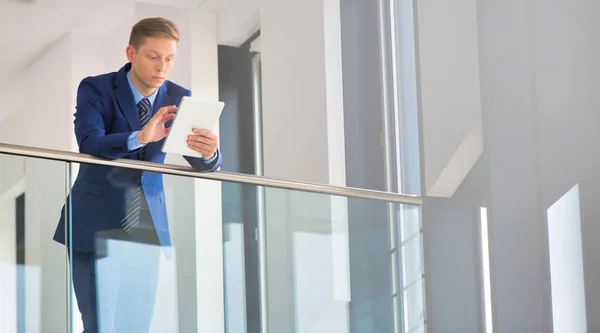 Jonge Zakenman Met Behulp Van Digitale Tablet Terwijl Leunend Balustrade — Stockfoto