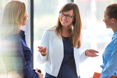 İş kadınları ofiste pencere karşı toplantı sırasında strateji planlama