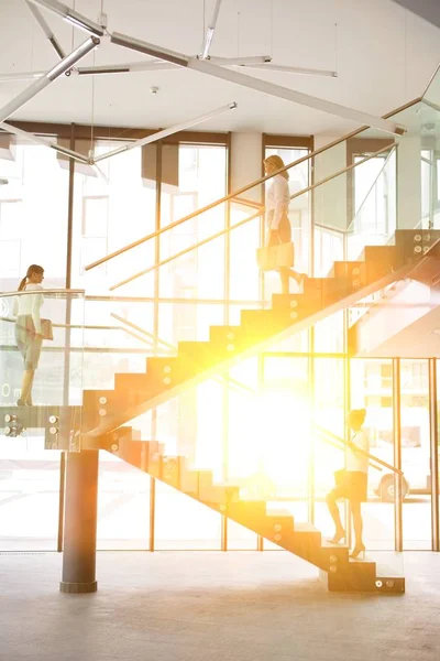 businesswomen walking on stairs in office building