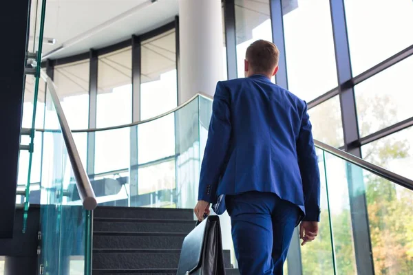 Young businessman climbing stairs in office