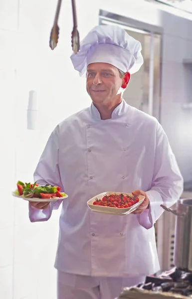 厨师在餐馆里把新鲜樱桃西红柿和沙拉放在盘子里 — 图库照片