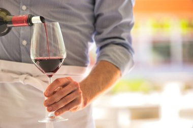 Garson midsection restoranda Wineglass kırmızı şarap dökme