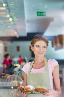 Restoranda kurabiye ve kahve servisi yapan genç bir garson.