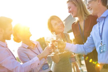 Genç iş arkadaşları çatıdaki başarı partisinde kadeh kaldırırken