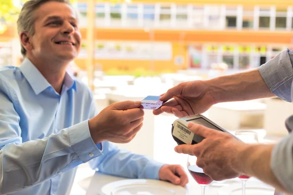 Χαμογελαστός Ώριμος Πελάτης Που Πληρώνει Μέσω Πιστωτικής Κάρτας Στο Εστιατόριο — Φωτογραφία Αρχείου