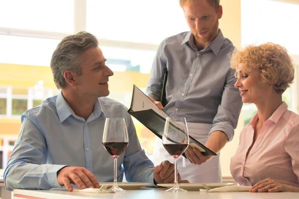 Junger Kellner Zeigt Reiferem Paar Restaurant Speisekarte — Stockfoto