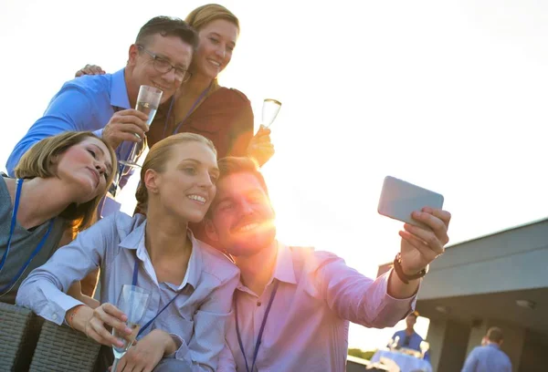 İş adamı çatı partisi sırasında meslektaşlarıyla selfie çekiyor. — Stok fotoğraf