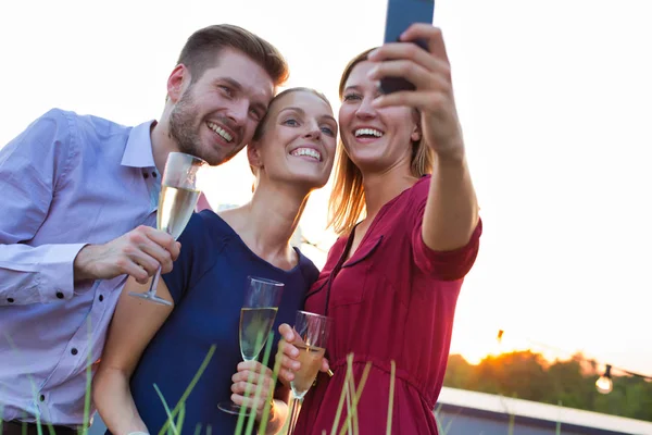 Gülümseyen iş kadını çatı arasında meslektaşlarıyla selfie çekiyor. — Stok fotoğraf